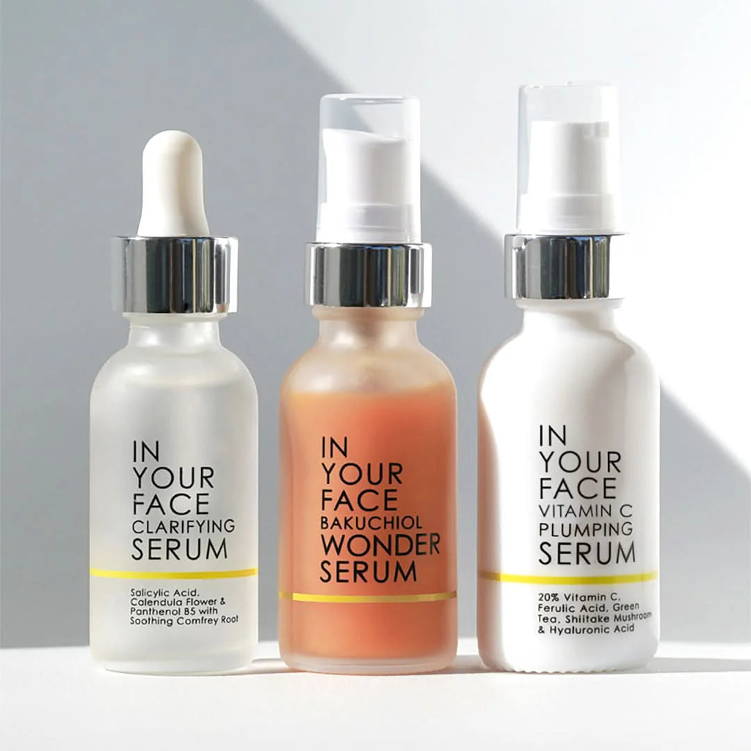 Three skincare serum bottles labeled 'In Your Face' on a light background