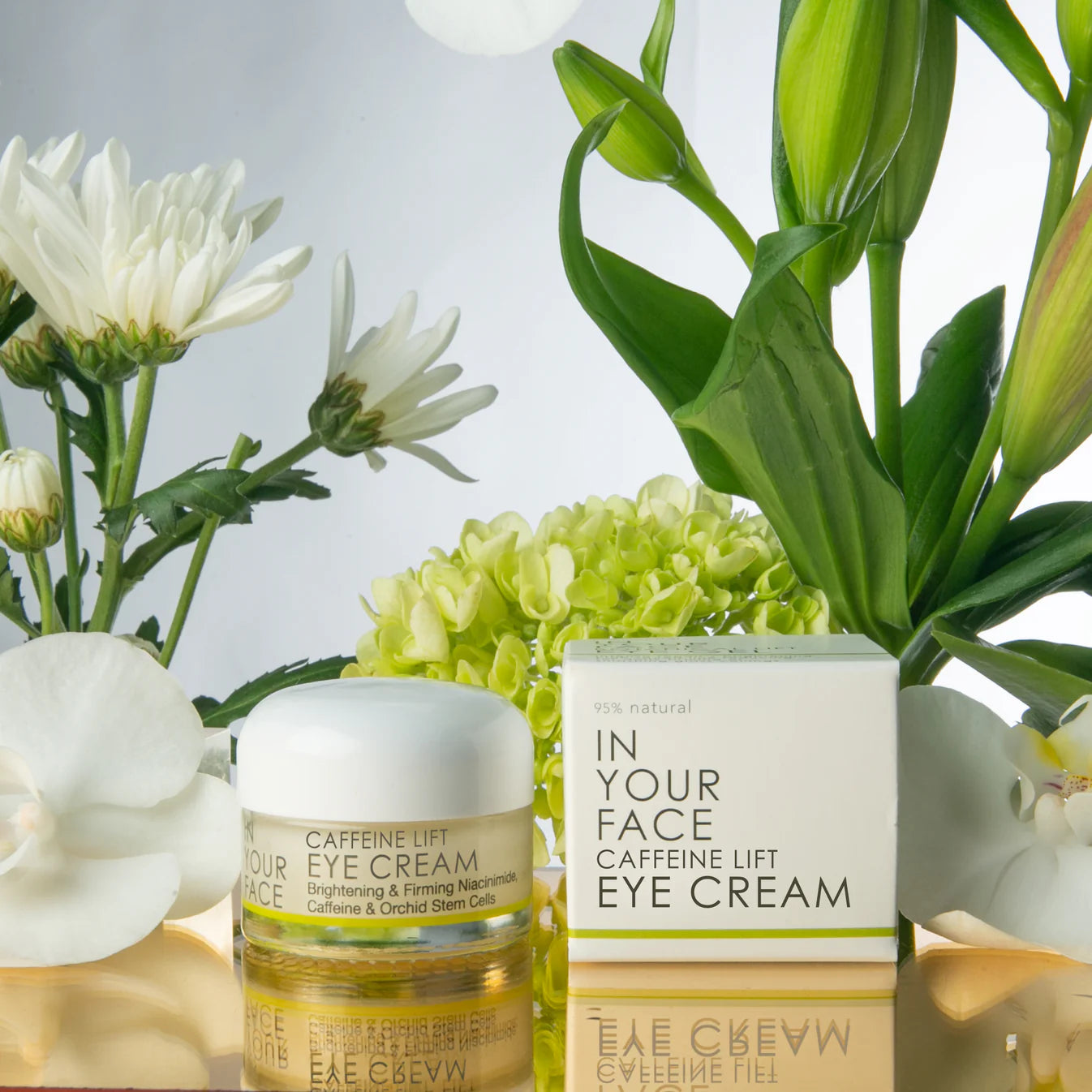 Caffeine Lift Eye Cream jar and box with natural flowers – brightening and firming skincare with niacinamide, caffeine and orchid stem cells