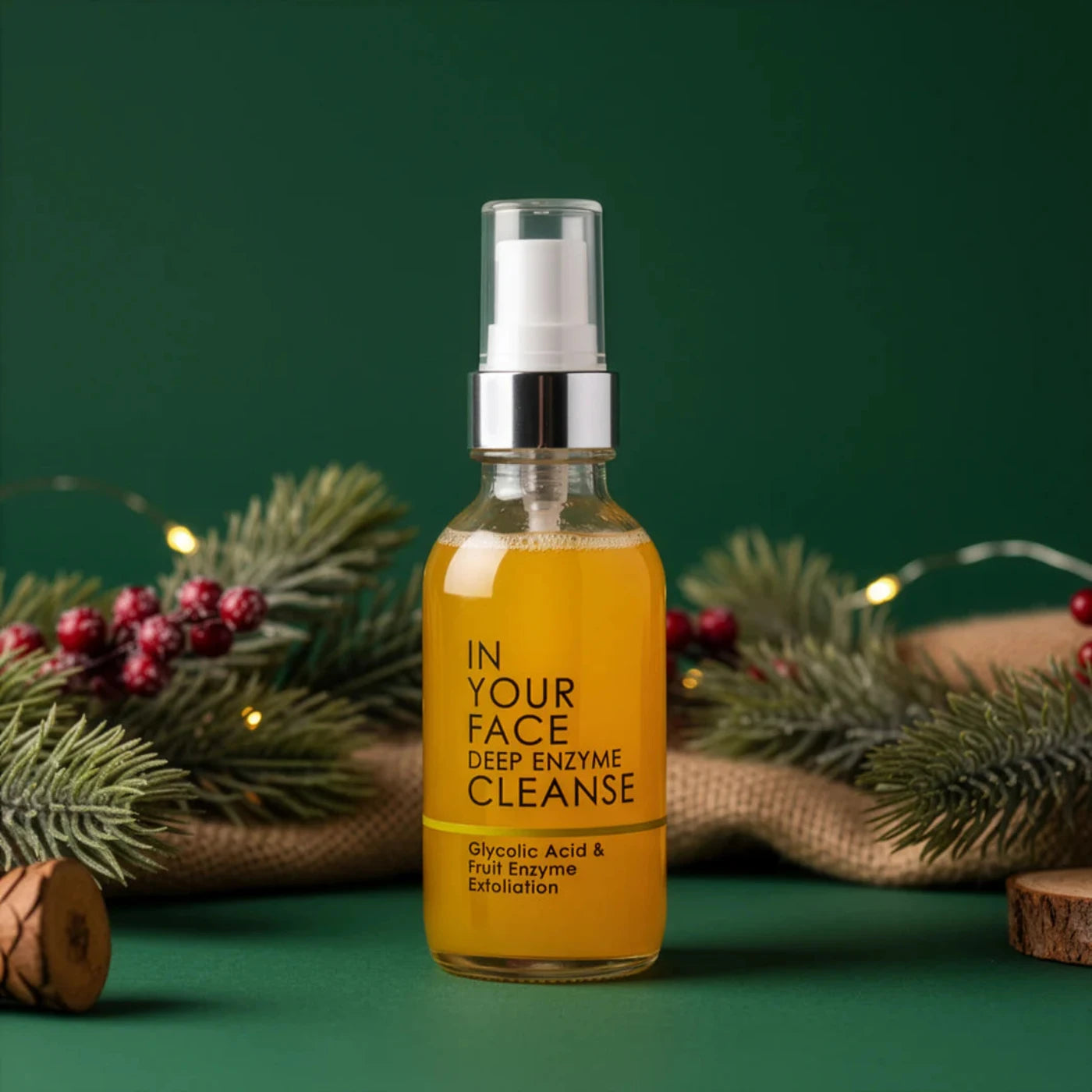 Bottle of 'In Your Face Deep Enzyme Cleanse' on a green background with decorative elements.