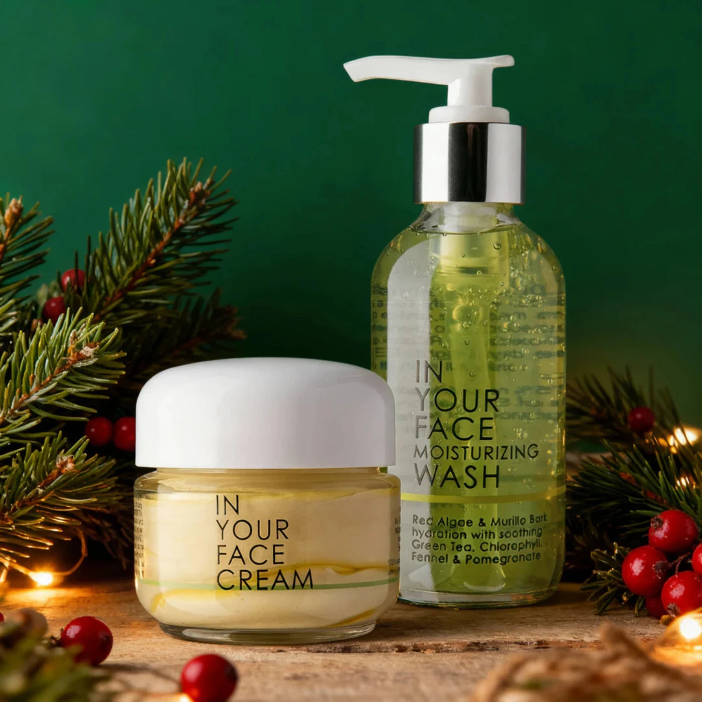 Cosmetic products including a cream jar and wash bottle with Christmas decorations on a wooden surface.