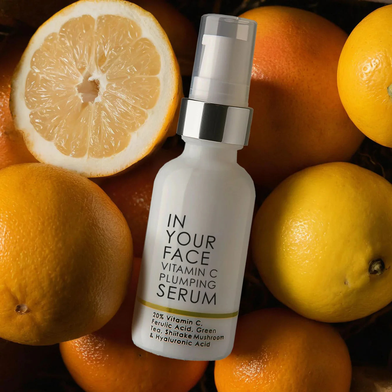 Vitamin C plumping serum bottle surrounded by oranges
