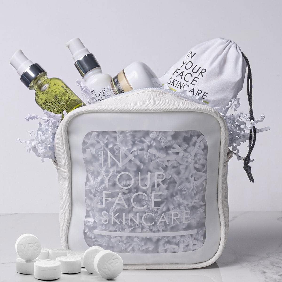 Skincare products and accessories from 'In Your Face Skincare' on a light gray background