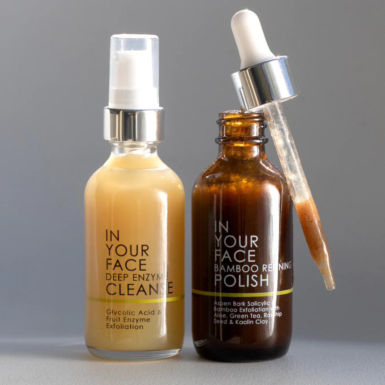 Two skincare products labeled 'In Your Face Deep Enzyme Cleanse' and 'In Your Face Bamboo Renewing Polish' on a gray background.