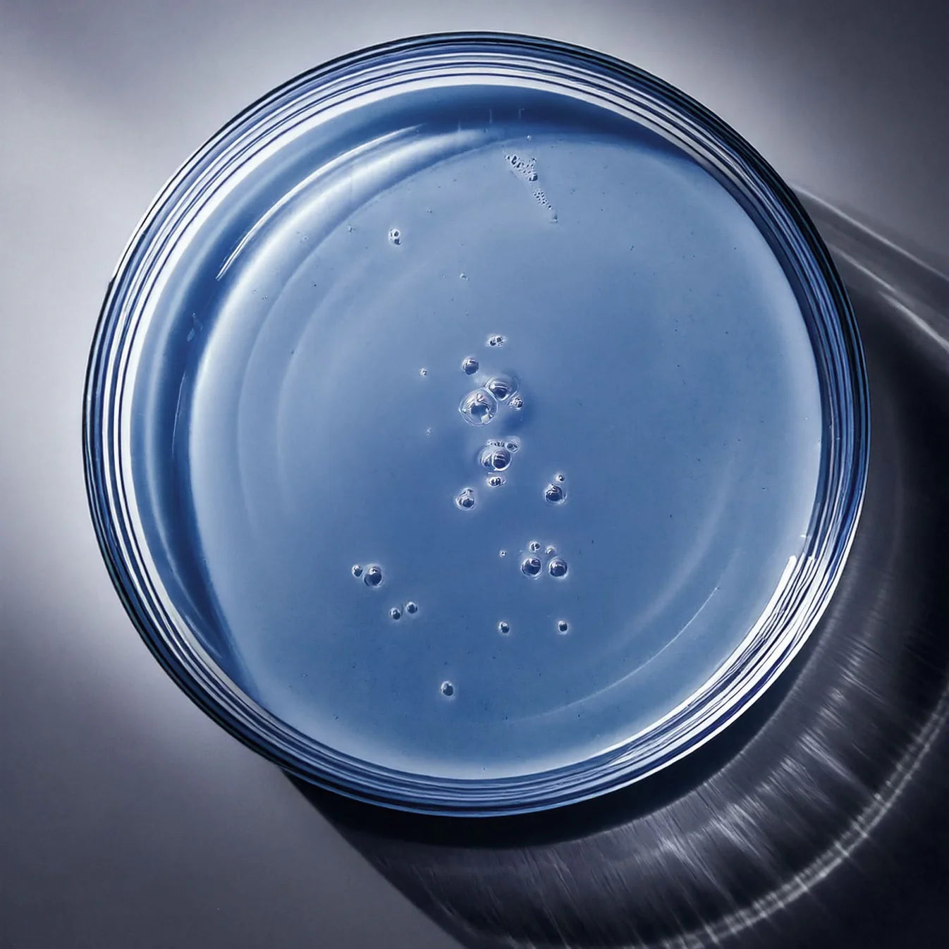 Close-up of blue Bio Peptide EGF-6 Firming Serum texture in glass dish