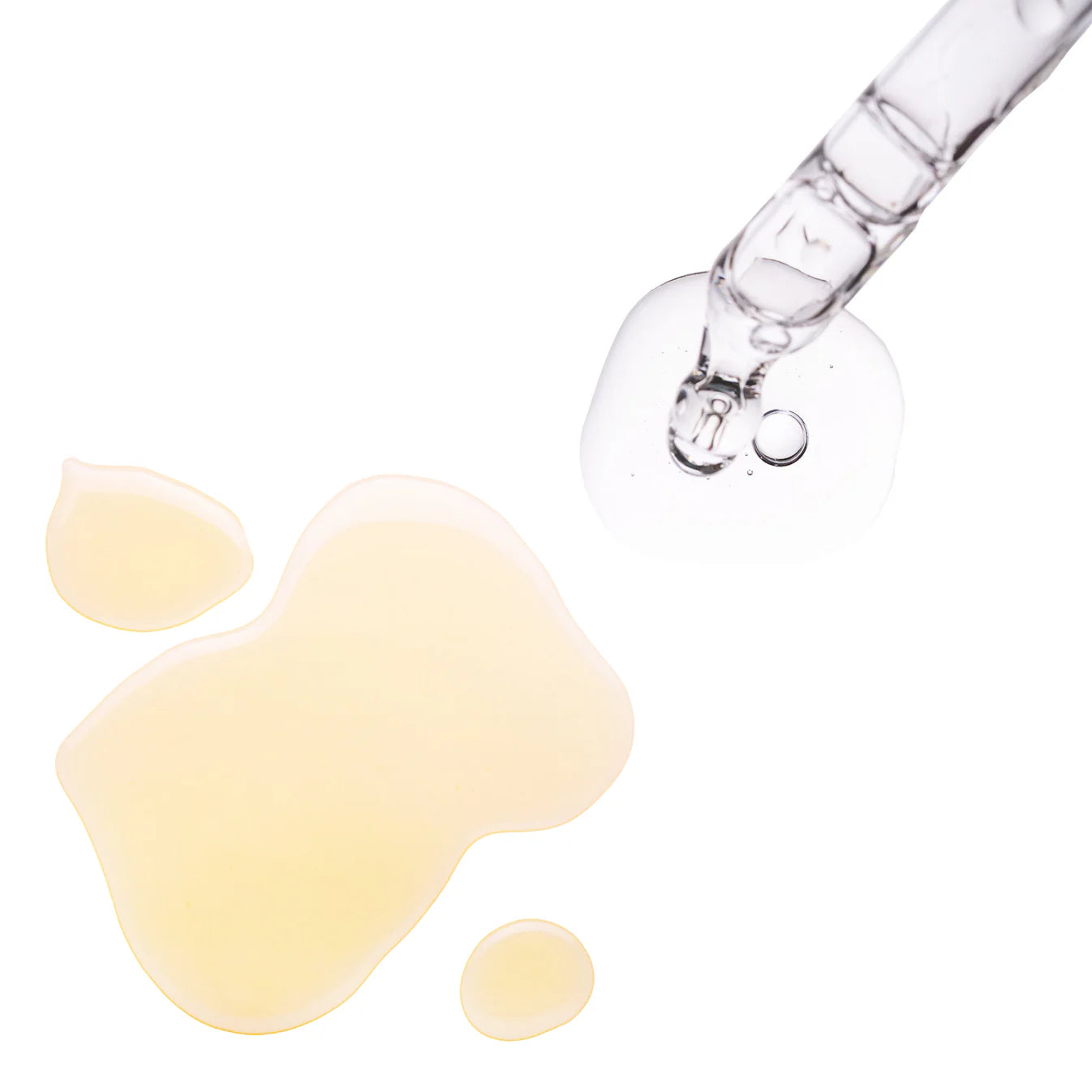 Glass dropper with clear liquid over a white background
