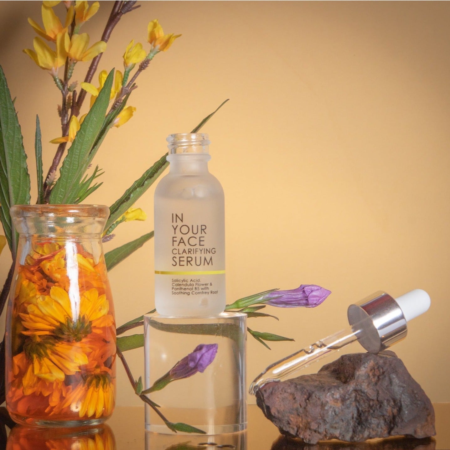 In Your Face Clarifying Serum in a frosted glass bottle, designed with salicylic acid and comfrey root to target blemishes.