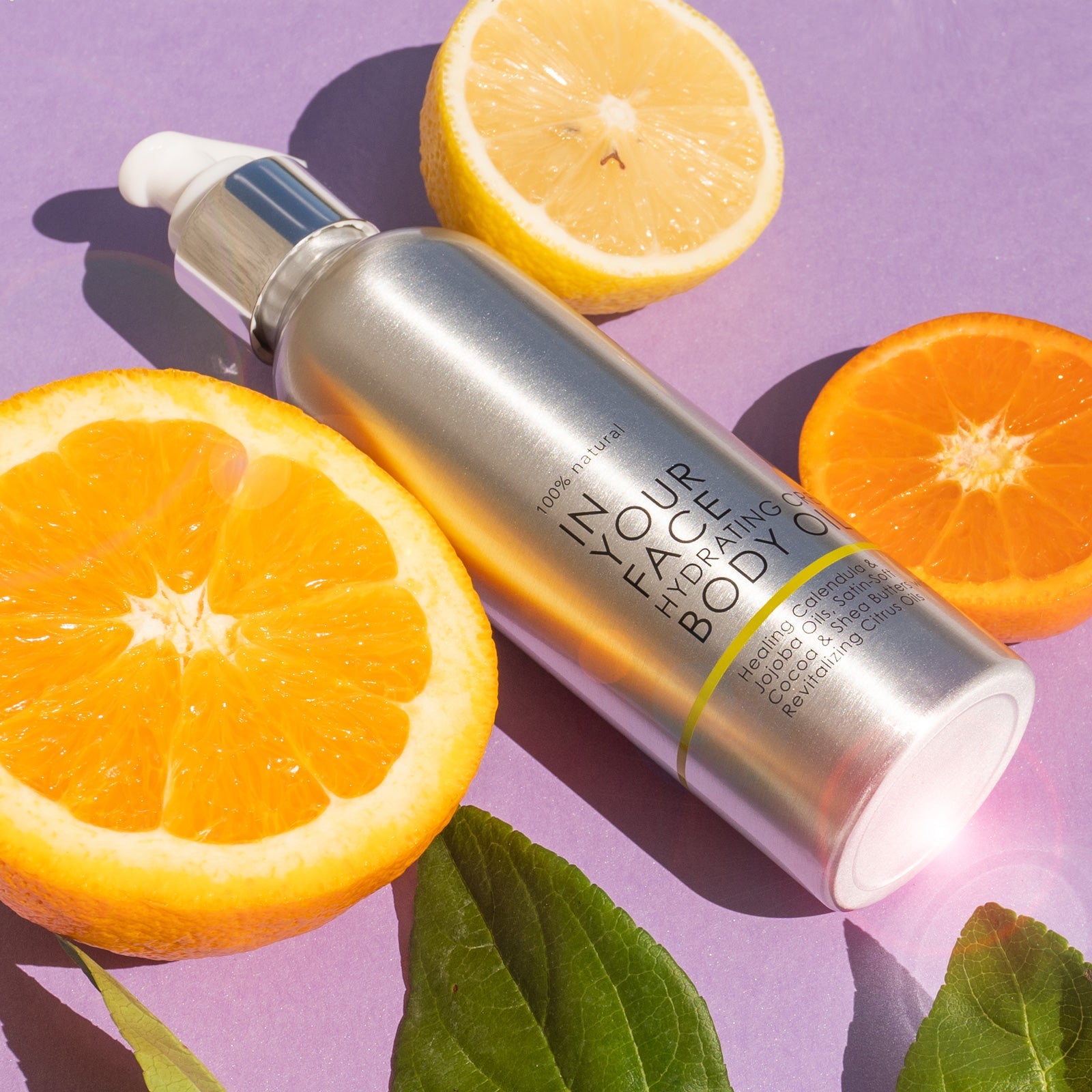 In Your Face Hydrating Creamy Body Oil in a sleek silver bottle with a pump, designed for nourishing and hydrating the skin with natural ingredients.