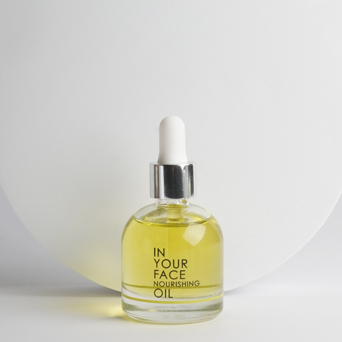 In Your Face Nourishing Oil in a glass bottle with a dropper, crafted to deeply nourish and hydrate the skin with natural oils.