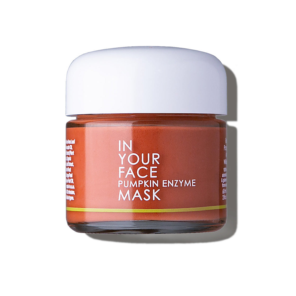 In Your Face Pumpkin Enzyme Mask in a small glass jar with a white lid, formulated to exfoliate and brighten the skin with pumpkin enzymes.