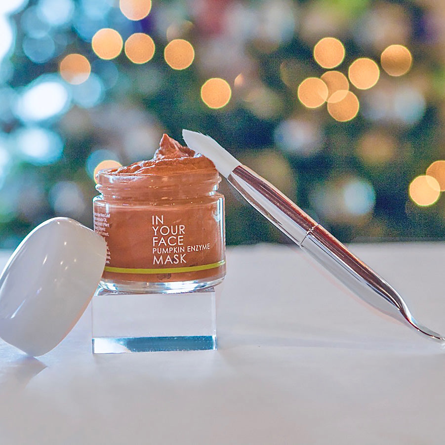 In Your Face Pumpkin Enzyme Mask in a small glass jar with a white lid, formulated to exfoliate and brighten the skin with pumpkin enzymes.