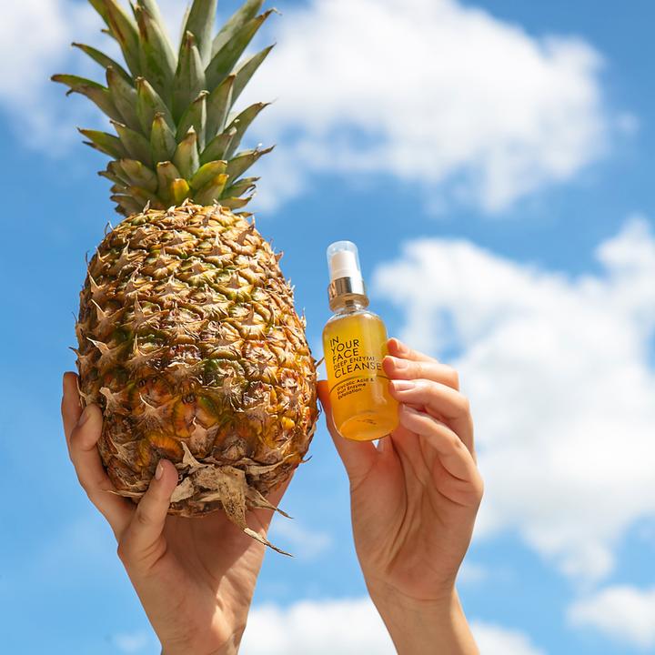 Glass bottle of "In Your Face Deep Enzyme Cleanse" featuring glycolic acid and fruit enzyme exfoliation for deep cleansing.