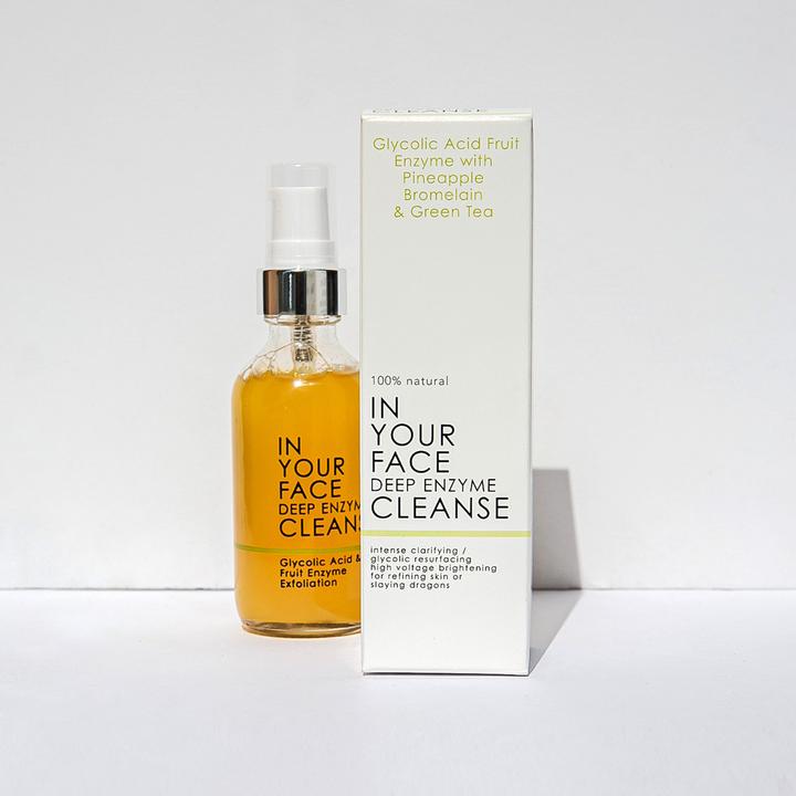 Glass bottle of "In Your Face Deep Enzyme Cleanse" featuring glycolic acid and fruit enzyme exfoliation for deep cleansing.
