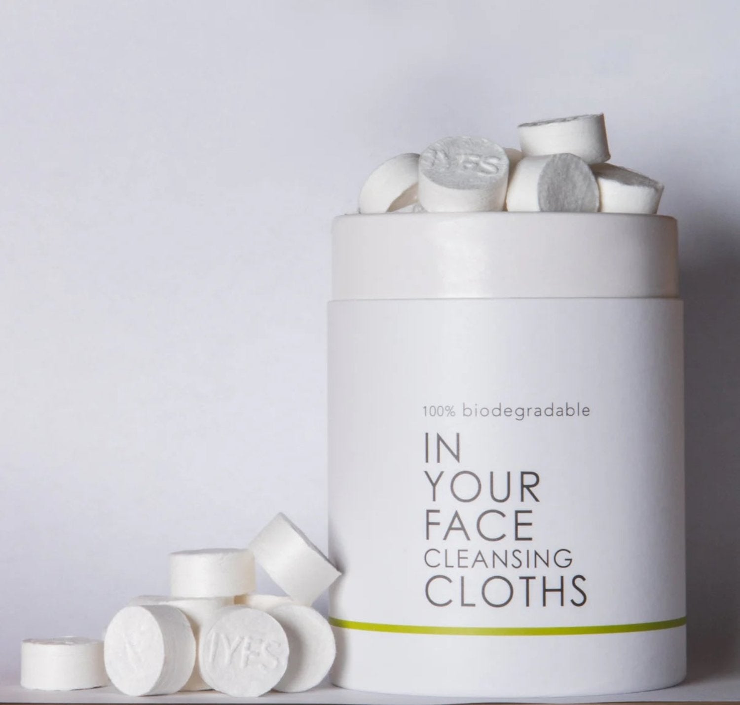 Open container of In Your Face Cleansing Cloths, showcasing compressed biodegradable cloths ready to expand with water for a sustainable skincare routine.