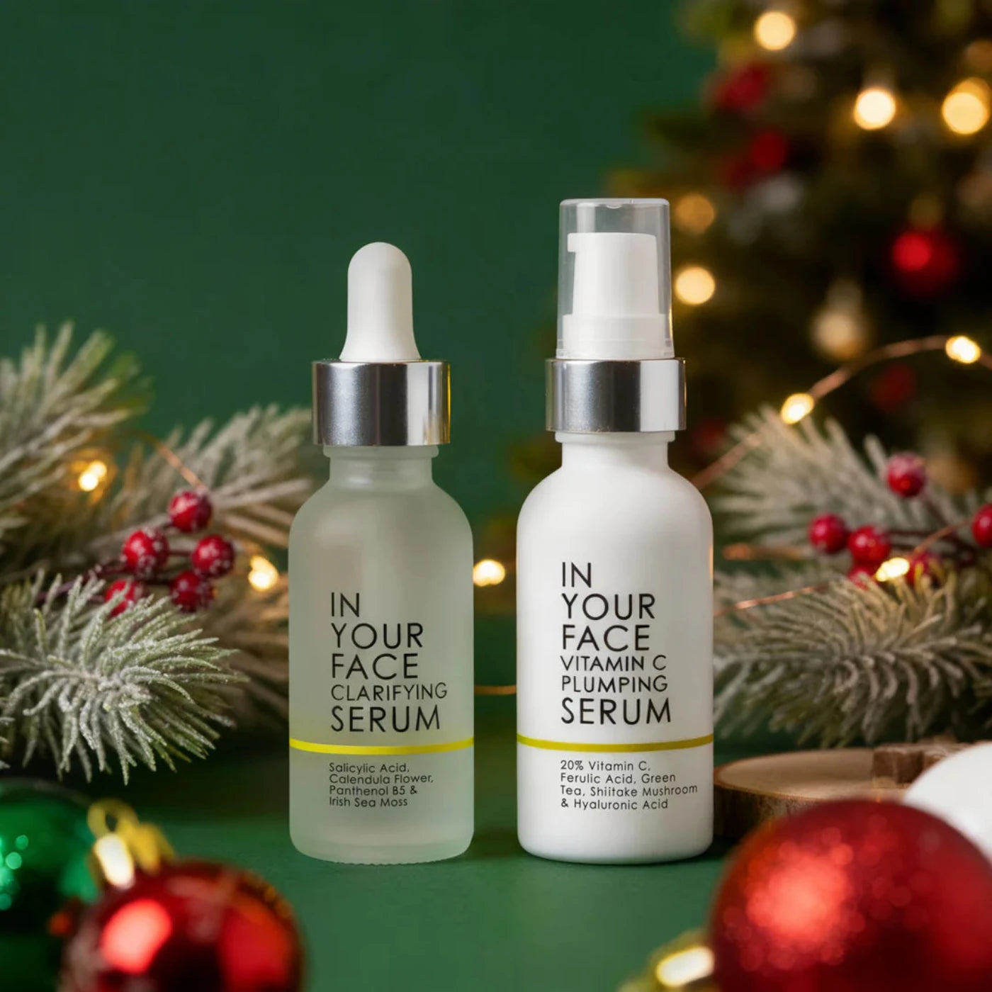 Two skincare serum bottles with Christmas decorations in the background