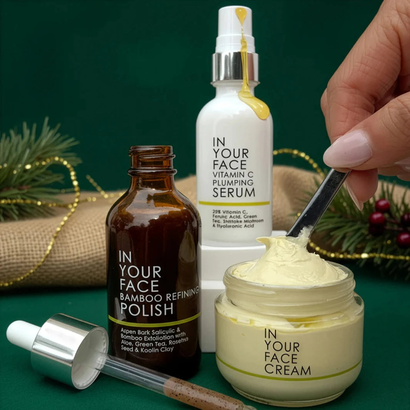 Cosmetic products including a serum, polish, cream, and a dropper on a green background.